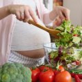 A pregnant woman makes a healthy salad.